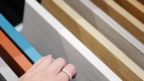 Woman touches countertop samples while choosing material in furniture showroom Stock Footage 346298063