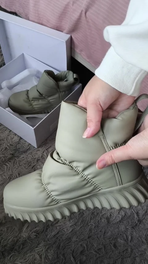 Woman touching, checking new winter shoes, in the background is a box of shoes Stock Footage 325033701