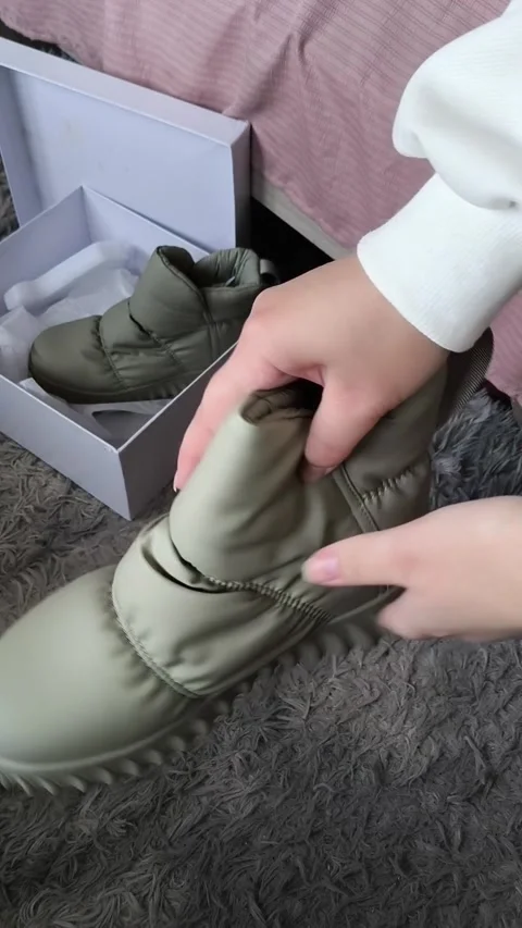 Woman touching, checking new winter shoes, in the background is a box of shoes Stock Footage 325033720