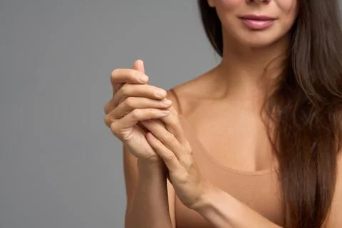 Woman touching her hands symbolizing self care, softness and skin nourishment Stock Photos