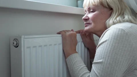 Woman touching radiator feeling cold at home Video stock 294816396