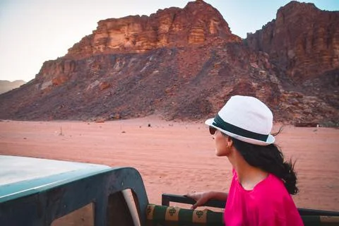 Woman tourist sit ride on 4wd truck on desert sunset tour on Wadi rum nature  Stock Photos
