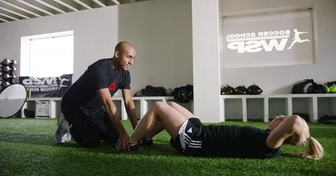 Woman with trainer doing sit ups in fitness studio 動画素材 78206896