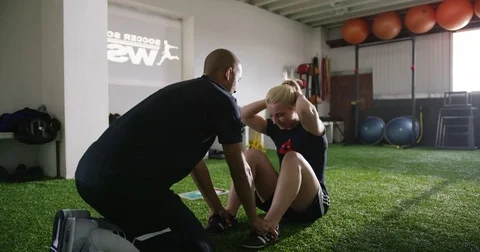 Woman with trainer doing sit ups in fitness studio 動画素材 78207286