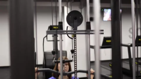 Woman training back on cable machine Stock Footage 328995894