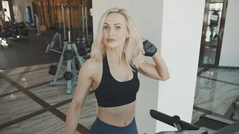Woman training on elliptical machine in modern gym Video stock 313326997