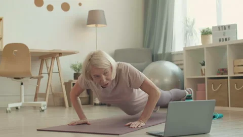 Woman Training at Home with Tutorial Stockbeeldmateriaal 140999960