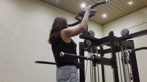 Woman training on pull up machine in modern gym Video stock 325603692