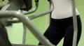 Woman trains in gym. Woman on a orbitrek exercise equipment HD Footage