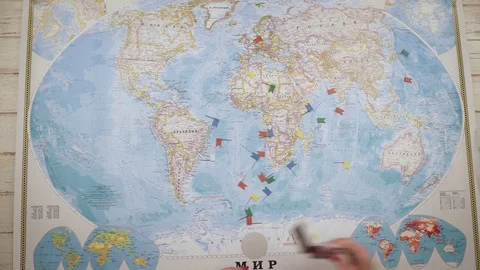 A woman traveler opens a map on the table and places flags in the cities of USA Stock Footage 84894552