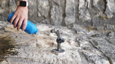 Thermos with a hot drink on mountain waterfall Stock Photo by