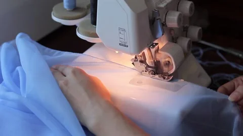 Woman treated tissue using overlock. Women's hands. Quickly sew close-up Stock Footage 67229442