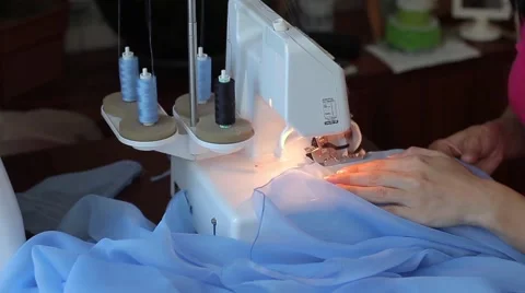 Woman treated tissue using overlock. Women's hands. Quickly sew close-up 動画素材 67229549