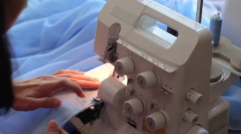 Woman treated tissue using overlock. Cuts the fabric edge. Women's hands Stock Footage 67229565