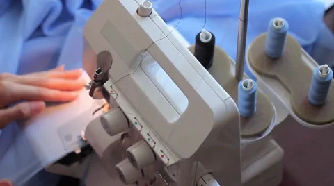 Woman treated tissue using overlock. Skeins of thread. Women's hands Stock Footage 67229585