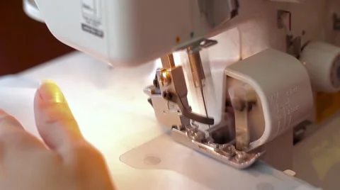 Woman treated tissue using overlock. Overlock foot closeup. Women's hands Stock Footage 67229721