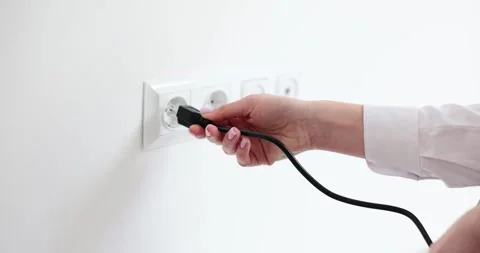 Woman tries to wire wrong plug to socket on white wall Stock Footage 278042804