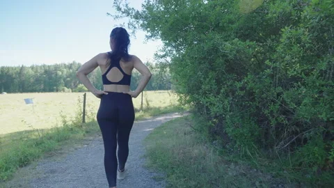 Woman trying to catch her breath after finishing her breath in nature Stock Footage