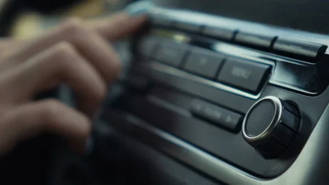 Woman Turning Up The Volume On The Car Radio Stock Photo