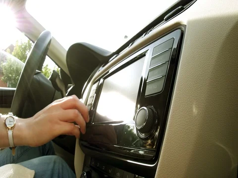 Woman turning volume on on car radio while driving Stock Footage