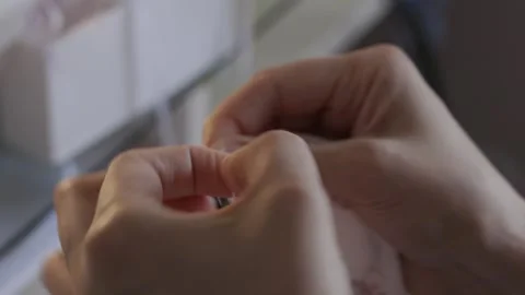 Woman tying threads after sewing up the edge of the fabric Video stock 279217153