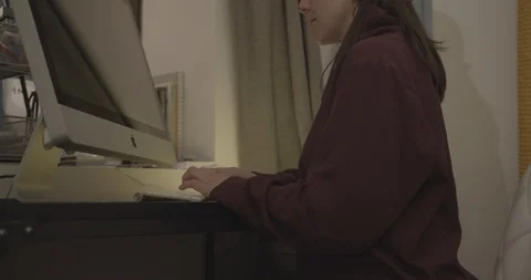 Woman types at a computer Stock Footage 129196306