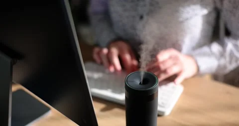 Woman types on keyboard while diffuser spreading fragrance Video stock 237013428