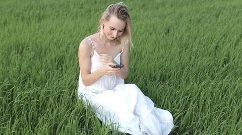 Woman types message lying down in the park: smartphone: mobile phone, outdoor Stock Footage 64012128