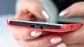 Woman types sms on her mobile phone. Close up of woman hands with red smartphone HD Footage