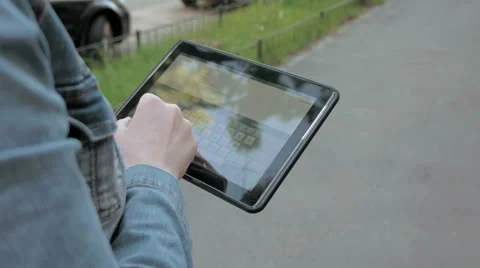 Woman types texts on tablet pc walking outdoors Stock Footage 63620939