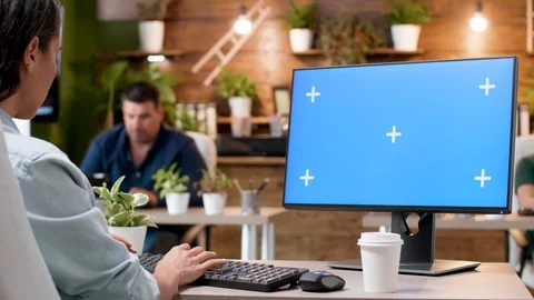Woman typing on a computer with a blue screen mock-up Stockbeeldmateriaal 112654330