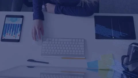 Woman typing on keyboard, causing blue code overlay, reaching tablet, using Video stock 335235899