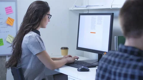 Woman typing on keyboard in front of computer in a shared office space Stock Footage 142212960