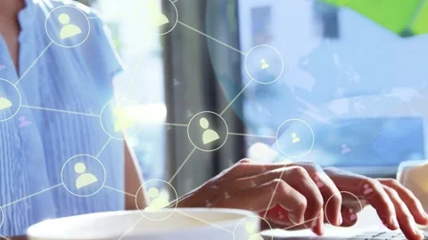 Woman typing on laptop at cafe, spawning network nodes over laptop, mapping Stock Footage 334351883