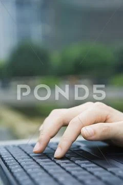 Woman Typing On Laptop Keyboard, Close-Up Of Hand