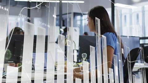 Woman typing on laptop, using mouse and scanning screen as faint finance graphs Stock Footage 333975325