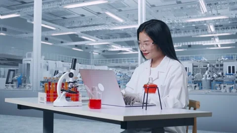 Woman Typing On A Laptop While Working With Microscope And Test Tube In The Lab Video stock 270224438