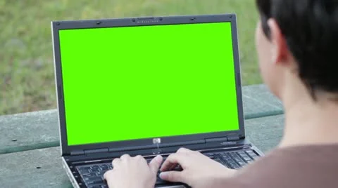 Woman typing at a park over the shoulder key green Stock Footage