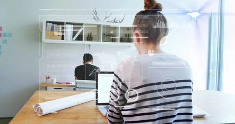 Woman typing at shared design table, laptop input spawning AR charts and map, Stock Footage 333833619