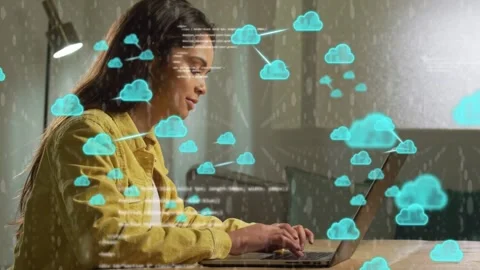 Woman typing while coding on laptop at home desk, causing cloud overlays Stock Footage 333193572