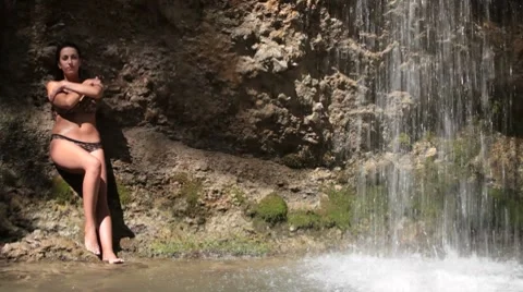 Woman under waterfall at resort Stock Footage