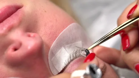 Woman undergoing eyelash procedure. process increasing eyelash extensions  girl. Vidéo 148677102