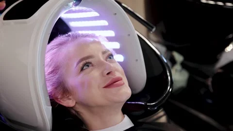 Woman undergoing led light therapy for hair and scalp treatment in beauty salon Stock Footage 313759126