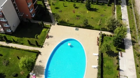 Woman on unicorn pool float in pool in front of hotel. Summer holidays Stock Footage 266799526