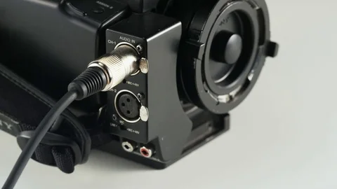 Woman Unplugging a Black Cable From a Video Camera Stock Footage 69718802