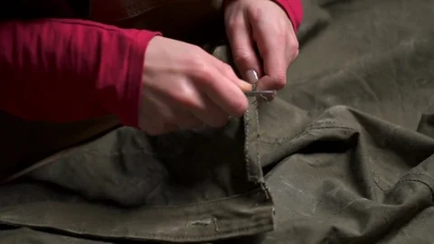 A woman unstitching the cloth using the sharp scissors closeup slow motion Stock Footage 71492835