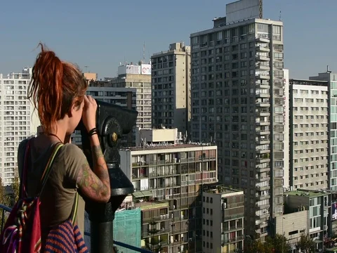 A woman use a binoculars to have a panoramic view of Santiago Stock Footage