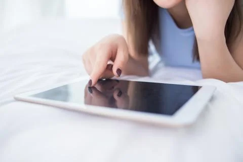 Woman use of mobile ipad on bed Stock Photos