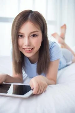 Woman use of mobile ipad on bed Stock Photos