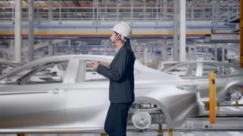Woman Use Smartphone While Walking and Looking Around In Car Factory Stock Footage 331631278